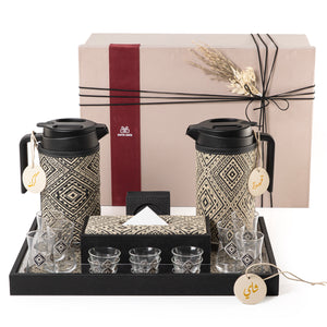 A black tray holding two thermoses with fabric covers, six coffee glasses, six tea glasses, six coasters, three labels "Tea, Karak, Coffee", and tissue box with a gift box