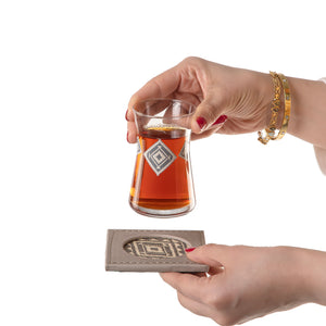 decorated tea glass with a grey coaster
