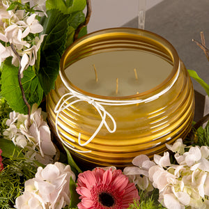 A flower tray with yellow glass candle