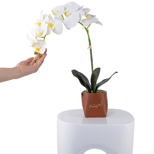 White orchid flower in a brown leather vase decorated by customized name 
