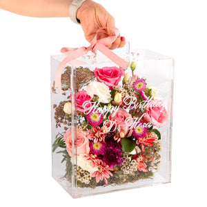 An Acrylic box filled with different types of flowers with customized name