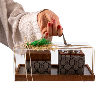 Brown tray with leather incense burner, and bakhor jar inside an acrylic box