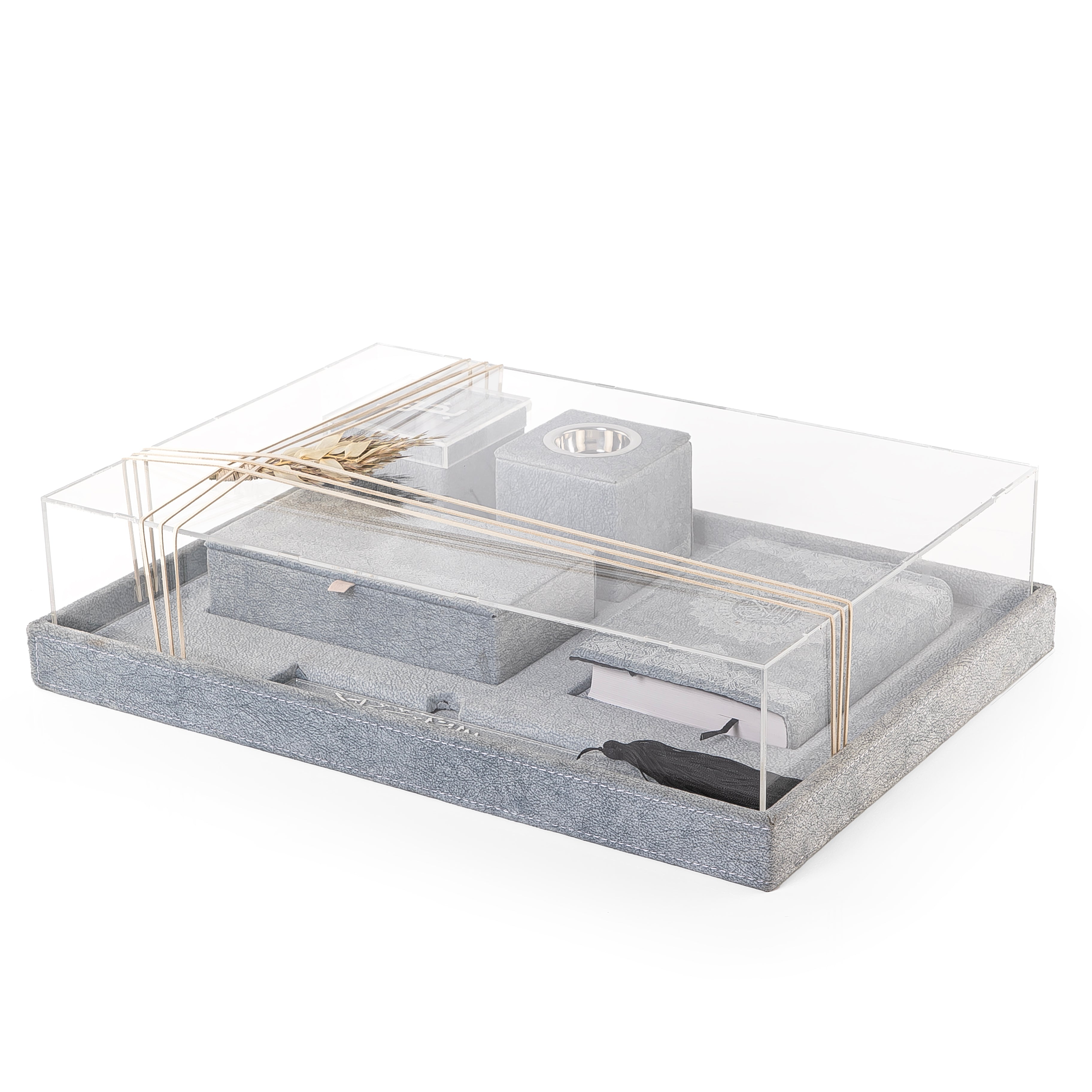 A blue set contains Quraan, incense burner, box, bakhor box, and bookmark in an acrylic box