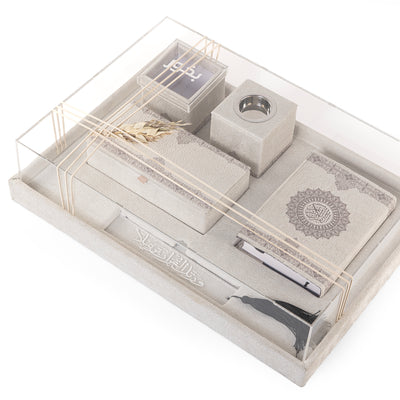 A grey set contains Quraan, incense burner, box, bakhor box, and bookmark in an acrylic box