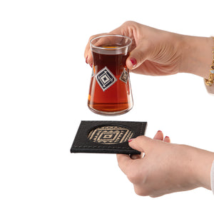 decorated tea glass with a black coaster 