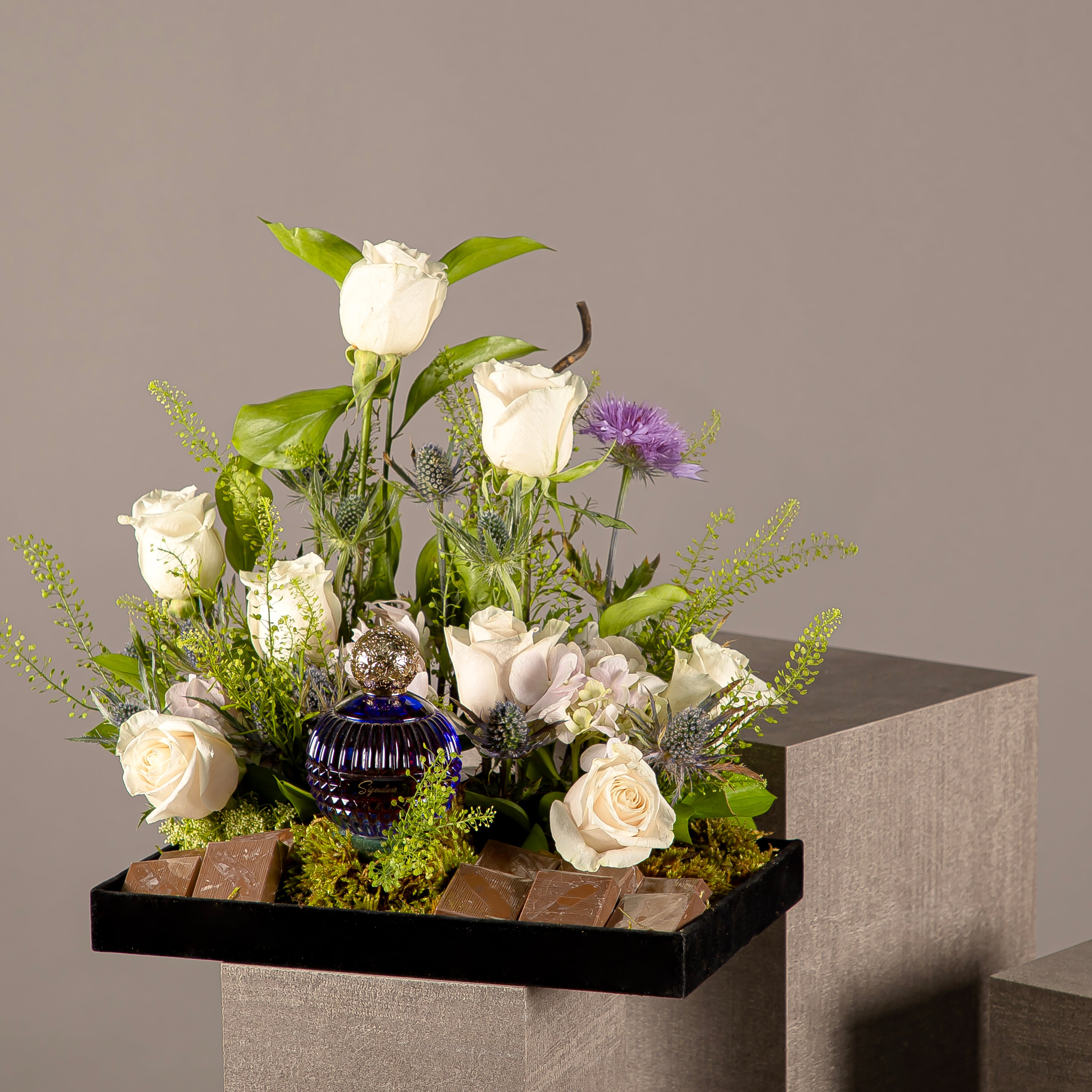 A chocolate tray with perfume from the Signature Collection, decorated with white roses