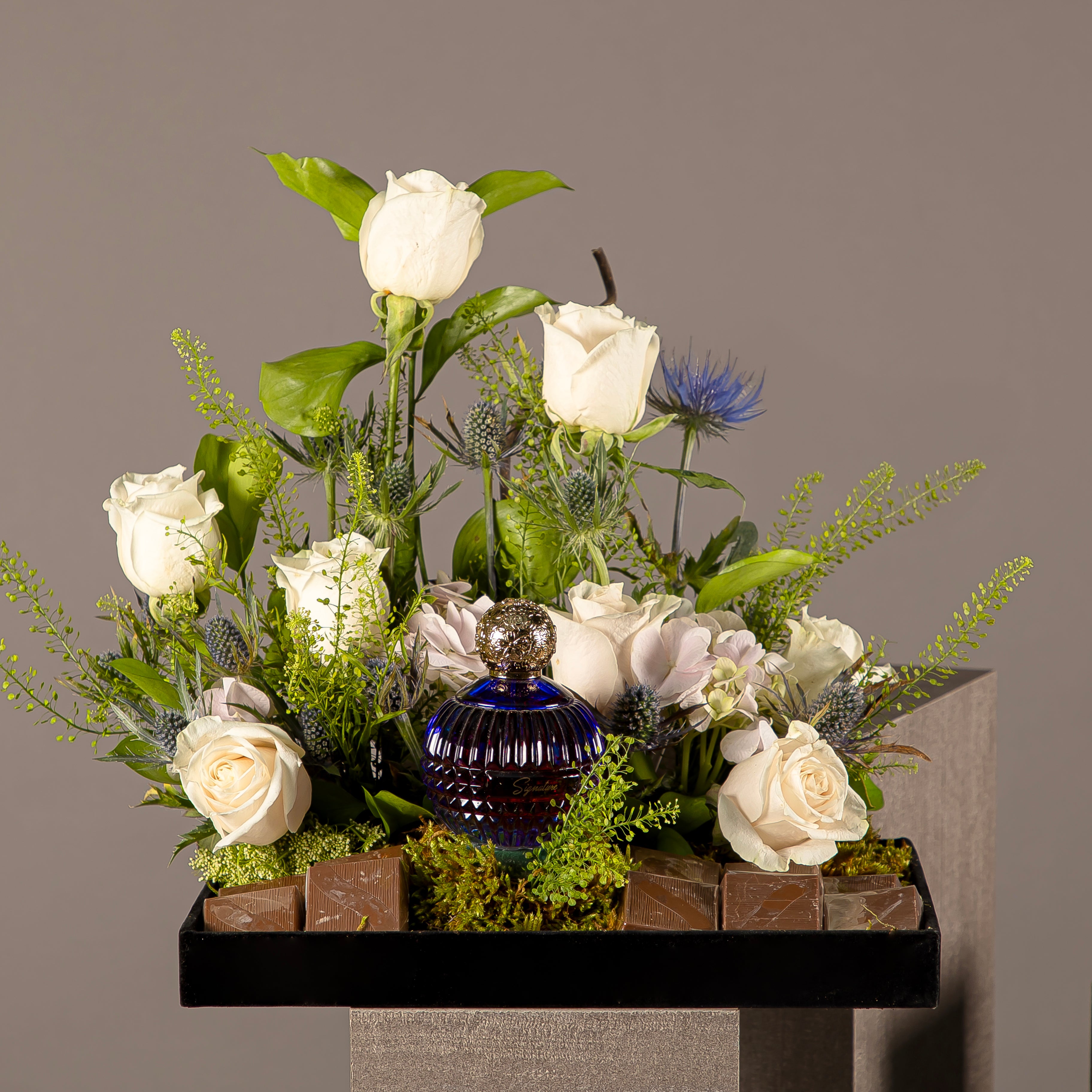 A chocolate tray with perfume from the Signature Collection, decorated with white roses