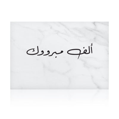 white marble greeting card with the words 'ألف مبروك' written on it