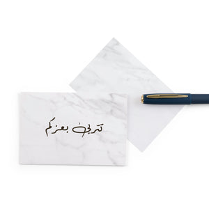 white marble new baby girl greeting card with the words 'تتربى بعزكم' written on it