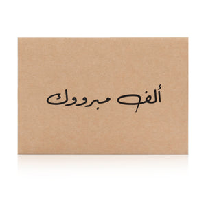 Beige greeting card with the words 'ألف مبروك' written on it