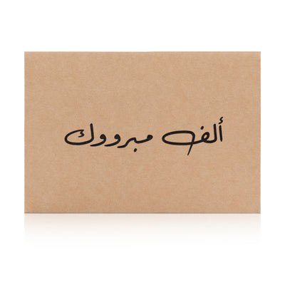Beige greeting card with the words 'ألف مبروك' written on it