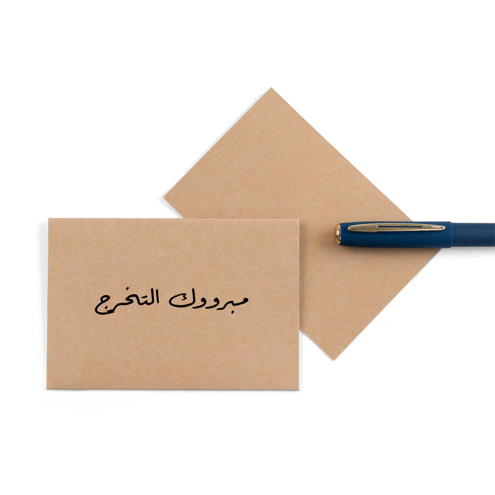 beige graduation greeting card with the word 'مبروك التخرج' written on it