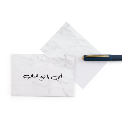 white marble greeting card for mother's day with the words 'أمي يا نبع الحنان' written on it