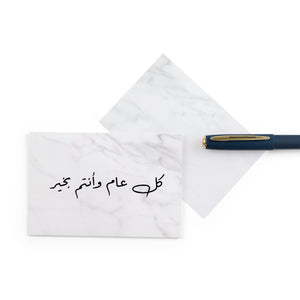 white marble greeting card with the words 'كل عام وأنتم بخير' written on it
