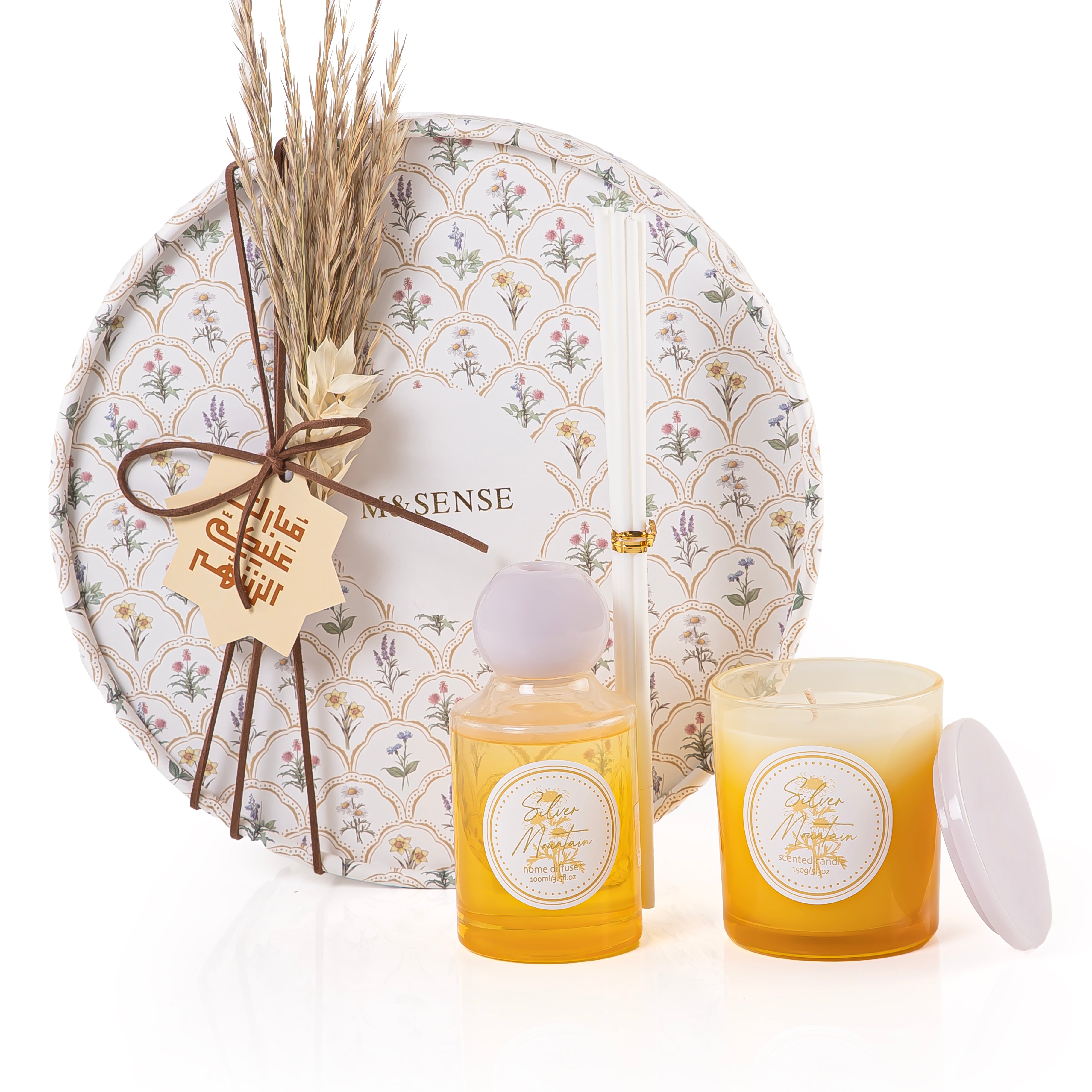 Circular decorated box with a customized name label contains diffuser, candle, and five sticks